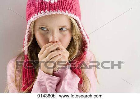 Stock Image - portrait of freezing girl wearing woollen winter hat. Fotosearch