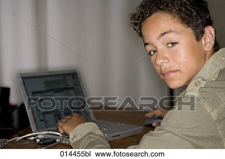 portrait of latino teenage boy sitting with his laptop View Large Photo Image Stock Image - portrait of latino teenage boy sitting with his laptop. Fotosearch