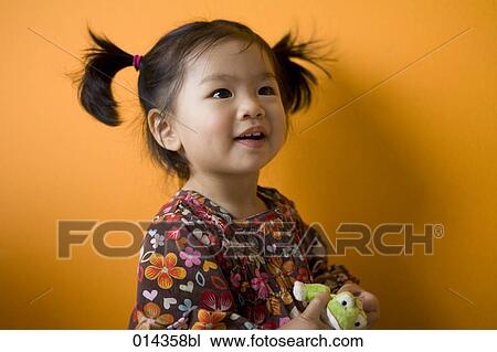 Stock Image - portrait of little asian girl with cuddly toy. Fotosearch