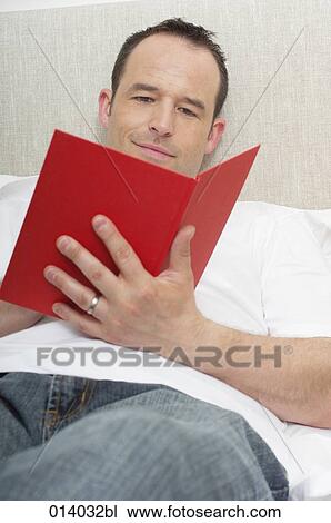 portrait of man lying on bed reading book View Large Photo Image Stock Image - portrait of man lying on bed reading book. Fotosearch