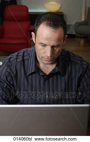 Stock Image - portrait of man working with laptop computer. Fotosearch