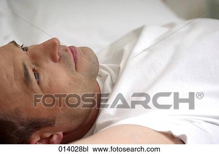 portrait of serious looking man lying on bed View Large Photo Image Stock Image - portrait of serious looking man lying on bed. Fotosearch