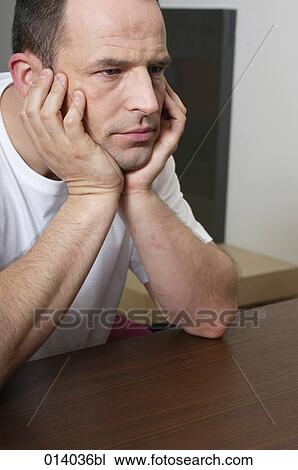 portrait of serious man sitting at table View Large Photo Image Stock Image - portrait of serious man sitting at table. Fotosearch