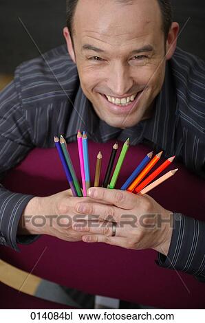portrait of smiling young businessman holding many colourful pencils View Large Photo Image Stock Image - portrait of smiling young businessman holding many colourful pencils. Fotosearch