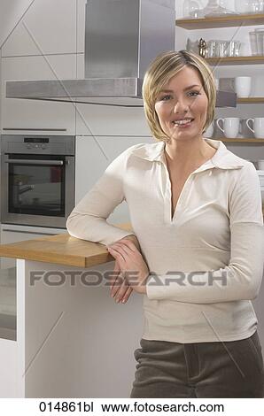 portrait of smiling young woman standing in kitchen View Large Photo Image Stock Image - portrait of smiling young woman standing in kitchen. Fotosearch