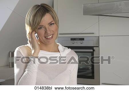 portrait of smiling young woman with cellphone in kitchen View Large Photo Image Stock Image - portrait of smiling young woman with cellphone in kitchen. Fotosearch