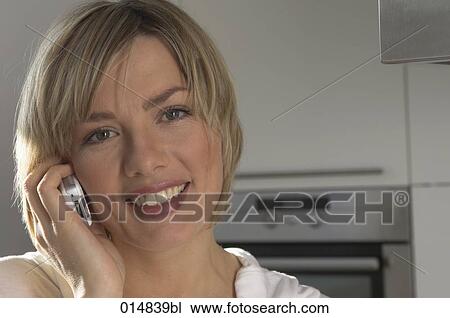 portrait of smiling young woman with cellphone in kitchen View Large Photo Image Stock Image - portrait of smiling young woman with cellphone in kitchen. Fotosearch