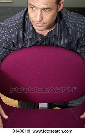 Stock Image - portrait of young businessman sitting on lounge chair. Fotosearch