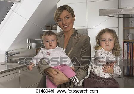 portrait of young businesswoman in kitchen with her two little daughters View Large Photo Image Stock Image - portrait of young businesswoman in kitchen with her two little daughters. Fotosearch