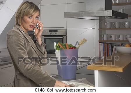 portrait of young businesswoman standing in kitchan and talking on mobile phone View Large Photo Image Stock Image - portrait of young businesswoman standing in kitchan and talking on mobile phone. Fotosearch
