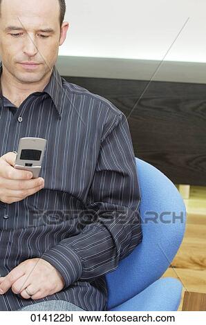 portrait of young man checking his mobile phone for text messages View Large Photo Image Stock Image - portrait of young man checking his mobile phone for text messages. Fotosearch