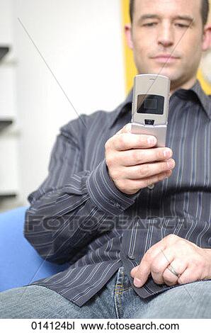 portrait of young man checking his mobile phone for text messages View Large Photo Image Stock Image - portrait of young man checking his mobile phone for text messages. Fotosearch