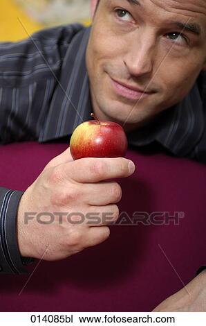 portrait of young man holding red apple View Large Photo Image Stock Image - portrait of young man holding red apple. Fotosearch