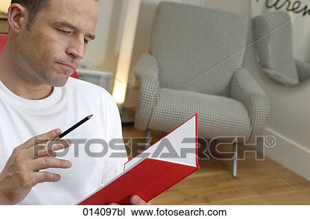 portrait of young man in living room with pen and journal View Large Photo Image Stock Image - portrait of young man in living room with pen and journal. Fotosearch
