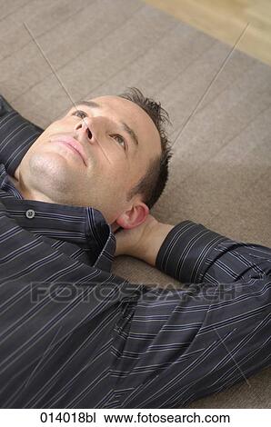 portrait of young man lying on rug with pensive expression View Large Photo Image Stock Image - portrait of young man lying on rug with pensive expression. Fotosearch