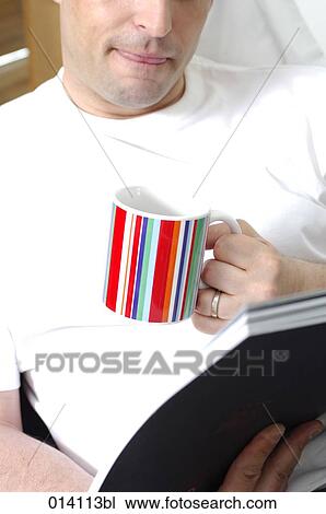 portrait of young man relaxing with cup of coffee or tea and book on sofa View Large Photo Image Stock Image - portrait of young man relaxing with cup of coffee or tea and book on sofa. Fotosearch