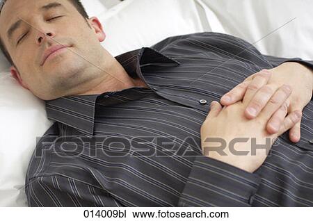 Stock Image - portrait of young man sleeping in bed. Fotosearch