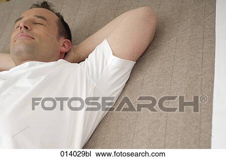 Stock Image - portrait of young man sleeping on bed. Fotosearch