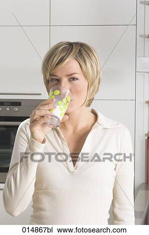 portrait of young woman drinking glass of milk in kitchen View Large Photo Image Stock Image - portrait of young woman drinking glass of milk in kitchen. Fotosearch