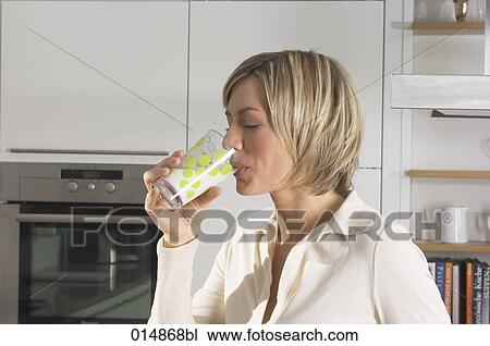 portrait of young woman drinking glass of milk in kitchen View Large Photo Image Stock Image - portrait of young woman drinking glass of milk in kitchen. Fotosearch