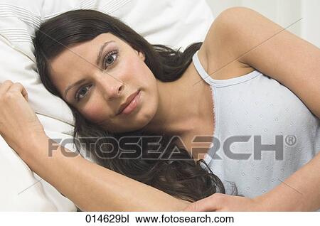portrait of young woman lying in bed View Large Photo Image Stock Image - portrait of young woman lying in bed. Fotosearch