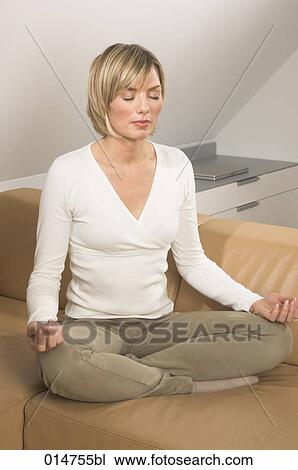 portrait of young woman meditating on sofa in living room View Large Photo Image Stock Image - portrait of young woman meditating on sofa in living room. Fotosearch