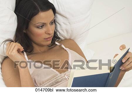 portrait of young woman reading book in bed View Large Photo Image Stock Image - portrait of young woman reading book in bed. Fotosearch