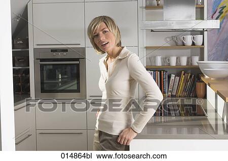 portrait of young woman standing in kitchen View Large Photo Image Stock Image - portrait of young woman standing in kitchen. Fotosearch