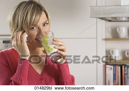 portrait of young woman with cellphone, drinking glass of milk in kitchen View Large Photo Image Stock Image - portrait of young woman with cellphone, drinking glass of milk in kitchen. Fotosearch