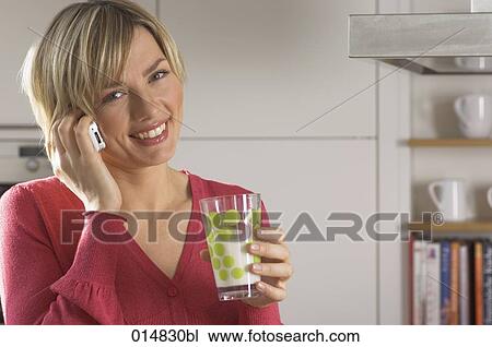 portrait of young woman with cellphone, drinking glass of milk in kitchen View Large Photo Image Stock Image - portrait of young woman with cellphone, drinking glass of milk in kitchen. Fotosearch