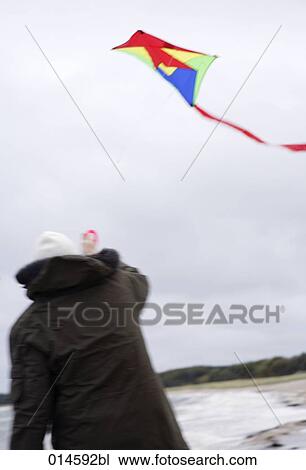 rear view of man playing with kite on beach in autumn View Large Photo Image Stock Image - rear view of man playing with kite on beach in autumn. Fotosearch