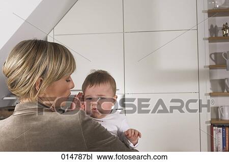 rear view of stressed young businesswoman holding baby View Large Photo Image Stock Image - rear view of stressed young businesswoman holding baby. Fotosearch