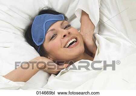 smiling young woman wearing sleep mask waking up in the morning View Large Photo Image Stock Image - smiling young woman wearing sleep mask waking up in the morning. Fotosearch