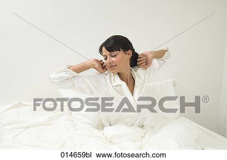 woman in white pajamas waking up in her bed in the morning View Large Photo Image Stock Image - woman in white pajamas waking up in her bed in the morning. Fotosearch