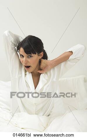 woman in white pajamas yawning in her bed in the morning View Large Photo Image Stock Image - woman in white pajamas yawning in her bed in the morning. Fotosearch