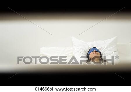 Stock Image - woman with sleep mask sleeping under observation . Fotosearch