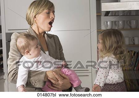 yawning young businesswoman looking at her little daughter View Large Photo Image Stock Image - yawning young businesswoman looking at her little daughter. Fotosearch