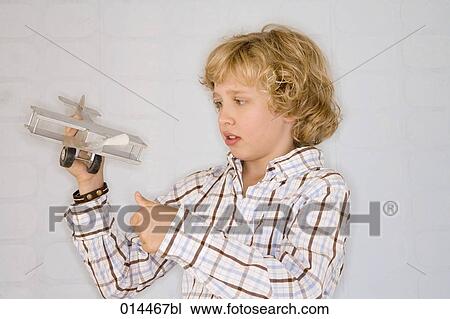 young boy looking at toy aeroplane in his hand View Large Photo Image Stock Image - young boy looking at toy aeroplane in his hand. Fotosearch