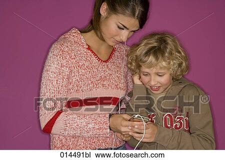 young boy sharing mp3 player with older sister View Large Photo Image Stock Image - young boy sharing mp3 player with older sister. Fotosearch