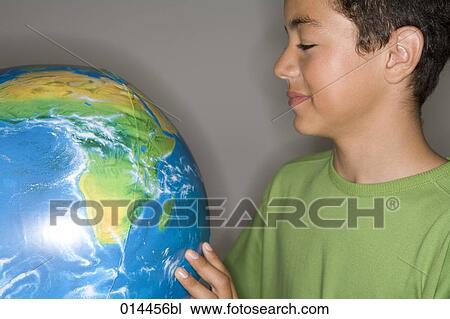 young boy wearing green looking at inflatable globe View Large Photo Image Stock Image - young boy wearing green looking at inflatable globe. Fotosearch