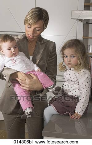 Stock Image - young businesswoman with her daughters one looking moody. Fotosearch