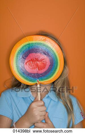 young girl hiding behind large colorful lollipop View Large Photo Image Stock Image - young girl hiding behind large colorful lollipop. Fotosearch