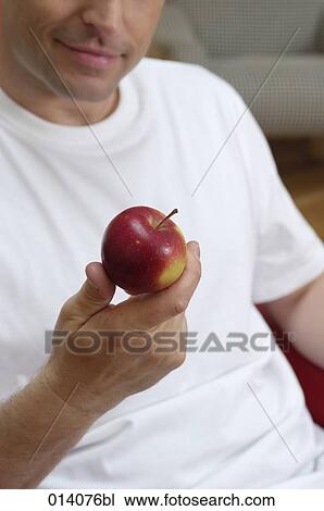 young man holding red apple in his hand View Large Photo Image Stock Image - young man holding red apple in his hand. Fotosearch