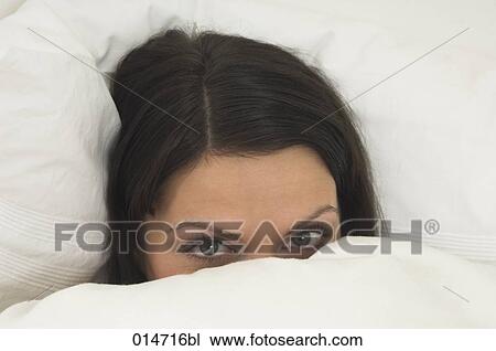 young woman hiding in bed behind duvet View Large Photo Image Stock Image - young woman hiding in bed behind duvet. Fotosearch