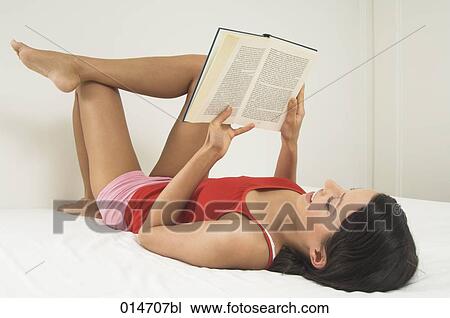 young woman lying on bed reading book View Large Photo Image Stock Image - young woman lying on bed reading book. Fotosearch