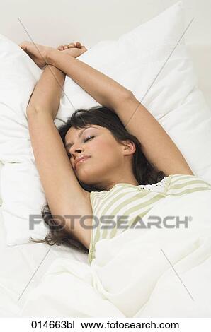 young woman stretching herself in her bed in the morning View Large Photo Image Stock Image - young woman stretching herself in her bed in the morning. Fotosearch