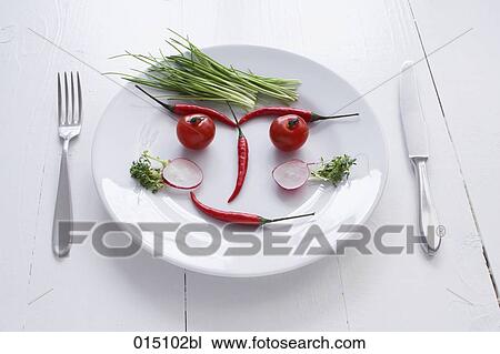 Stock Image - face on plate formed from different vegetables. Fotosearch