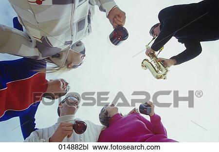 group of friends enjoying themselves in winter drinking mulled wine and listening to saxophone player View Large Photo Image Stock Image - group of friends enjoying themselves in winter drinking mulled wine and listening to saxophone player. Fotosearch
