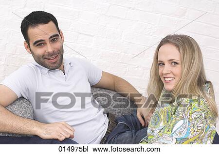 happy young couple sitting on armchair together View Large Photo Image Stock Image - happy young couple sitting on armchair together. Fotosearch