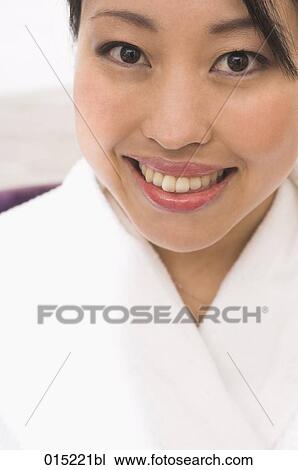Stock Image - headshot of smiling japanese woman in white bathrobe. Fotosearch